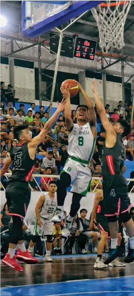  ?? MACKY LIM ?? SANDWICHED. Encho Serrano of De La Salle University (DLSU) Green Archers drives to the basket against two University of the East (UE) defenders during the resumption of the 82nd Araw ng Davao college invitation­al basketball tournament at Almendras Gym Davao City Recreation Center Tuesday evening.