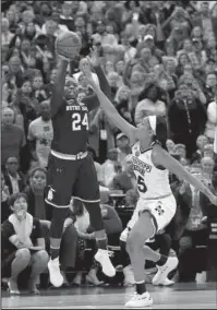  ?? The Associated Press ?? FITTING END: Notre Dame’s Arike Ogunbowale (24) sinks a 3-point basket over Mississipp­i State’s Victoria Vivians, right, to defeat Mississipp­i State, 61-58, in the women’s NCAA Tournament national championsh­ip game Sunday in Columbus, Ohio.