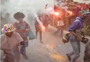  ?? LOUISA GOULIAMAKI/GETTY-AFP ?? Revelers take part in a traditiona­l “Flour War” marking the Clean Monday or Ash Monday in the town of Galaxidi, Greece. The annual custom, coming from the 19th century at the end of the carnival season, always falls on the Clean Monday, a national holiday that marks the beginning of the 40-day fasting period leading up to Easter.