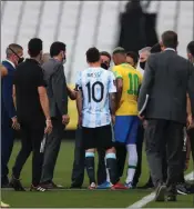  ?? Photo: Getty Images ?? Halted… Argentina captain Lionel Messi and Brazilian players gather at the side of the pitch a few moments later to discuss the stoppage.