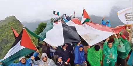  ?? Photo courtesy Aqsa Working Group ?? Indonesian activists wave Indonesian and Palestinia­n flags at the top of Muria Mountain in Kudus, Central Java on Nov. 13.