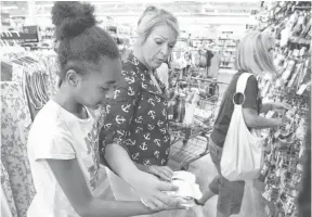  ?? MICHAEL PATRICK, AP ?? Jennifer Henry, center, and daughter Makaela, 9, shop at a Wal-Mart in Alcoa, Tenn. Wal-Mart is working hard to lure backto-school shoppers.