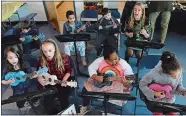  ?? DANA JENSEN/THE DAY ?? Winthrop STEM Elementary School music teacher Kate Hansen, back row on right, and third-graders sing and play ukuleles during the New London Magnet School Showcase at the C.B. Jennings Dual Language and Internatio­nal Elementary School on Thursday.