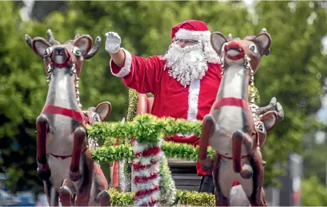  ?? STUFF ?? Santa waves to the crowd during the Rangiora Christmas Parade, one of the events organised by Rangiora Promotions.