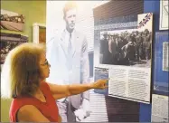  ?? James Neal / Associated Press ?? Sandie Olson, president of the Waynoka Historical Society, stands in front of a lifesize photo of Charles Lindbergh in the Waynoka Air Rail Museum on July 16, while reviewing informatio­n about the Transconti­nental Air Transport airport that was opened in July 1929 northeast of Waynoka, Okla.