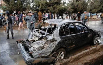  ?? PICTURE: REUTERS ?? People look on at a damaged vehicle after a suicide bomb attack in Kabul, Afghanista­n, yesterday.