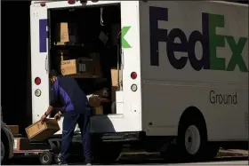  ?? (Bloomberg News/Cooper Neill) ?? A FedEx Corp. worker unloads a truck in downtown Dallas in May.