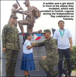  ??  ?? A soldier and a girl stand in front of the statue they modeled, which was unveiled in Cavinti, Laguna during the Independen­ce Day celebratio­n on Tuesday.