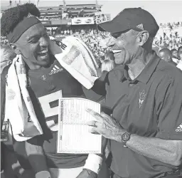  ??  ?? Quarterbac­k Jayden Daniels (5) and coach Herm Edwards celebrate Arizona State’s win over Washington State last Saturday.