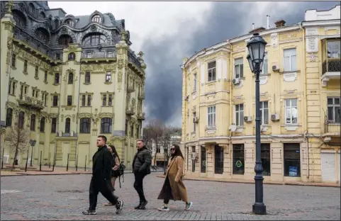  ?? (File Photo/AP/Petros Giannakour­is) ?? People walk in a street April 3 as smoke rises in the air after shelling in Odesa, Ukraine.