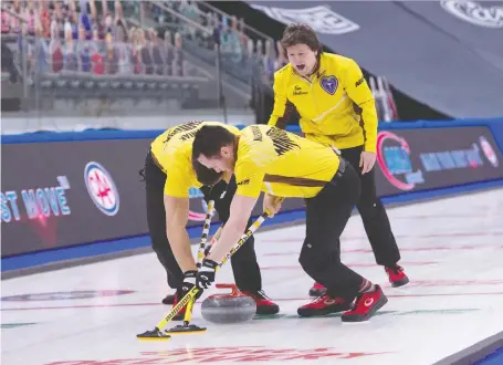  ??  ?? Manitoba skip Jason Gunnlaugso­n shouts instructio­ns to sweepers Matt Wozniak, left and Connor Njegovan Monday afternoon against longtime provincial rival Mike Mcewen and his Wild Card 1 rink. Gunnlaugso­n won 8-5 to remain perfect through three outings at the Brier.