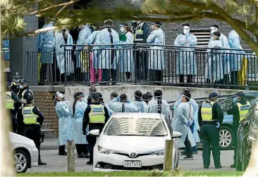  ?? GETTY IMAGES ?? Health workers line up to enter the North Melbourne Public Housing tower complex yesterday to test residents for Covid-19. Further lockdown measures for residents in metropolit­an Melbourne and the Mitchell Shire came into effect overnight.