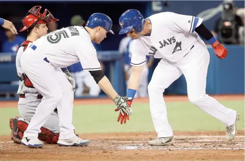  ??  ?? Russell Martin félicite son coéquipier Troy Tulowitzki, qui vient de frapper un Grand Chelem en troisième manche.