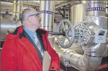  ?? FRAM DINSHAW/ TRURO NEWS ?? David Gray, Dean of Dalhousie Agricultur­al Campus, inspects pipes leading to the thermal oil heater at the campus’s new Biomass Energy Plant Tuesday. Burning wood chips feed a turbine to produce up to 1 MW of energy.