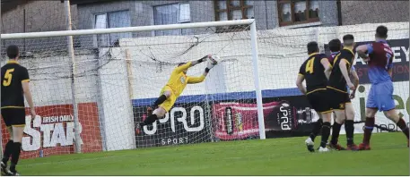  ??  ?? Chris Mulhall (right) watches as his shot is saved by Cobh Wanderers goalkeeper Michael Devine.