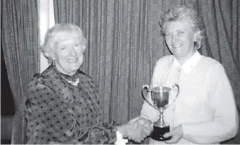  ?? 01_B46twenty0­5 ?? Past captain of Lamlash Ladies’ Golf Club, Joy Elliot presents Ellie Jones with the Championsh­ip Trophy at the club’s prize-giving dinner.