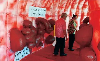  ??  ?? VARIAS personas caminan dentro de un colon de plástico para ver los daños causados por el cáncer.