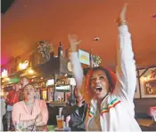  ?? ELAINE THOMPSON/ASSOCIATED PRESS ?? Soccer fan Tizita Assefa, right, of Bellevue, Wash., celebrates a goal by Serbia against Switzerlan­d on Friday in a Seattle sports bar. With no team in the soccer tournament, Americans’ support is being courted by several teams.