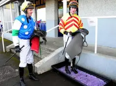  ?? Photo: Healy Racing ?? PRECAUTION: Jockeys Johnny Barry and Mark O’Hare disinfect their boots after riding at Naas yesterday.