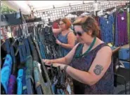  ?? GENE WALSH — DIGITAL FIRST MEDIA ?? Nita Kerns and Holli Bushnell set up merchandis­e at their Eagle Ray Trader during the 56th annual Philadelph­ia Folk Festival in Upper Salford on Aug. 17.
