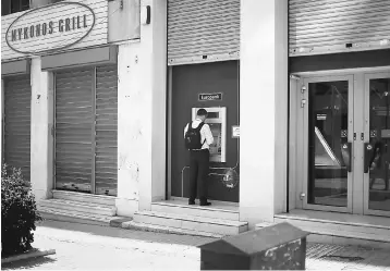  ??  ?? A man uses an ATM at a Eurobank branch in Athens. Greece will make its first return to the debt markets in three years on Tuesday, testing the waters to see if it can begin to wean itself off bailout loans after tough reforms. — Reuters photo