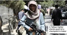  ??  ?? A Taliban fighter stands guard at a checkpoint in Kabul