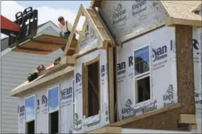  ?? KEITH SRAKOCIC — THE ASSOCIATED PRESS ?? In this Thursday photo, builders work on the roof of a home under constructi­on at a housing plan in Jackson Township, Butler County, Pa. On Friday the Commerce Department reports on U.S. home constructi­on in May.