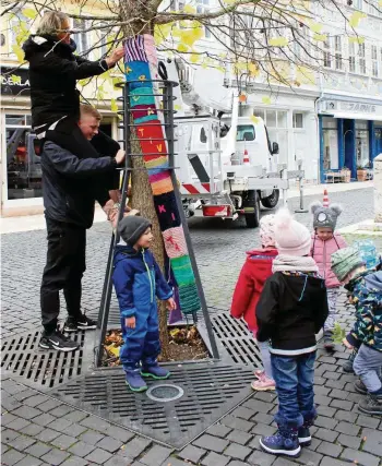  ?? SABINE SPITZER (2) ?? Strick-chic: Der Praktikant der Phantasia-kita, Niclas Höpfner, nahm Erzieherin Cordula Istel auf die Schultern, damit diese das wollene Kunstwerk besser anbringen konnte.