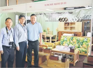  ??  ?? Sarawak Furniture Industry Associatio­n president Lai King Min (centre) posing in front of an exhibition booth at the eighth annual Sarawak Furniture & Home Expo.