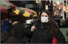  ?? MARK LENNIHAN – THE ASSOCIATED PRESS ?? A woman, who declined to give her name, wears a mask Thursday in New York. For the first time in the U.S., the new virus from China has spread from one person to another, health officials said Thursday.