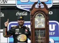  ?? STEVE HELBER — THE ASSOCIATED PRESS ?? Martin Truex Jr. (19) celebrates with the winners’ trophy after winning the NASCAR Cup Series race in Martinsvil­le, Va., Sunday.