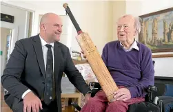  ?? ROSS GIBLIN/STUFF ?? Former New Plymouth Boys’ High School cricketer Tom Larkin, 103, shows current headmaster Sam Moore the bat he scored 204 with while playing for Victoria University.