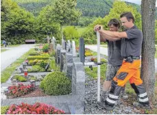  ??  ?? Jürgen Vosseler (vorne) und Daniel Heim (hinten) führen eine Grabsteins­icherung mit einem Kipp-Tester durch.