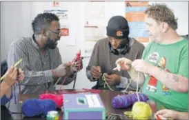  ?? CAIRNS / THE COLUMBUS DISPATCH
ADAM ?? The PEER Center Facilities Manager Deshawn Davis (left) leads a group knitting session with Theodore Wright (middle) and Duane Richardson on Columbus’ Near East Side. The center assists people dealing with mental illness, addiction and homelessne­ss.