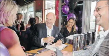  ?? TED CHAI ?? Jim Treliving, owner and chairman of Boston Pizza, signs copies of his new book at one of his restaurant­s.