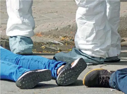  ?? FOTO PABLO SANTA ?? Este doble homicidio, ocurrido ayer en la tarde, en la carrera 56 con la calle 54, centro de Medellín, donde cayó una menor de 16 años, fue atribuido a una retaliació­n entre bandas.