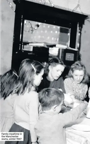  ??  ?? Family mealtime in the Manchester slums, winter 1947
