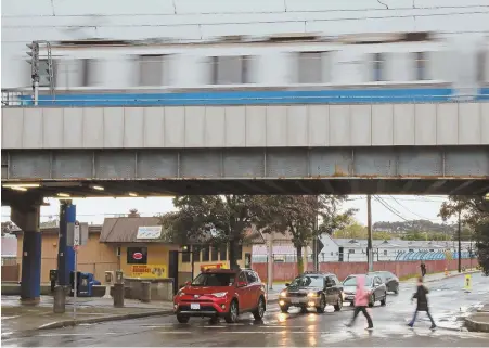  ?? STAFF PHOTOS BY MATT WEST ?? UNEASE: Beachmont store owners, such as Frank Pioppi, right, have mixed feelings about Amazon potentiall­y coming to the site of former Suffolk Downs. Above, an MBTA Blue Line train whizzes into the local station above Beachmont Roast Beef restaurant as...