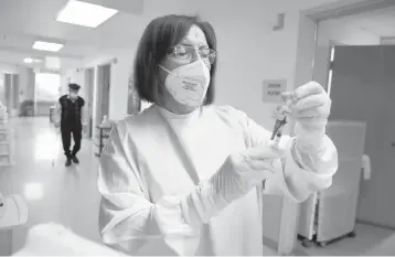  ?? MARIO TAMA/GETTY ?? Susana Azapyan prepares a dose of COVID-19 vaccine to administer to a resident at the Ararat Nursing Facility in Los Angeles. Residents and staff at long-term care facilities are on the CDC’s highest priority list for vaccinatio­ns.