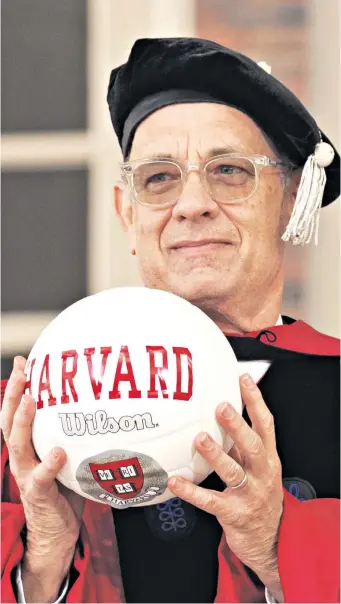  ?? Cast Away. ?? Wilson II Tom Hanks holds an emblazoned volleyball as he receives an Honorary Doctor of Arts degree at Harvard. A volleyball named Wilson co-starred with him in