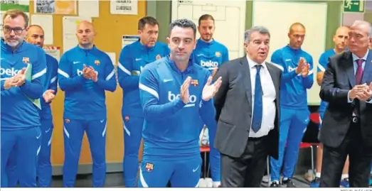  ?? MIGUEL RUIZ / FCB ?? Xavi Hernández con su cuerpo técnico y junto a Joan Laporta en el vestuario del Barcelona, ayer.