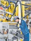  ?? FOTO: SONG WEIWEI ?? Arbeiter in einem Werk des chinesisch­en Autobauers Saic: Während anderswo Rezession herrscht, strahlt Deutschlan­ds größter Handelspar­tner vor Optimismus.