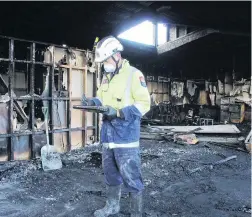  ?? PHOTO: VIV LOGIE ?? Investigat­ion . . . Fire and Emergency New Zealand West Coast fire safety officer Sam Buglar inspects the scene of a suspicious fire that destroyed an abandoned classroom block at the old Greymouth Intermedia­te School.