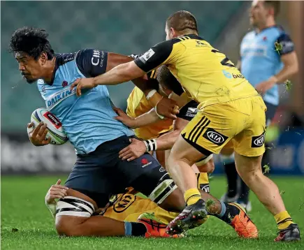 ?? GETTY IMAGES ?? Three Hurricanes combine to bring down Waratahs giant Will Skelton in Sydney last night.