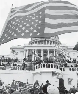  ?? THOMAS P. COSTELLO USA TODAY NETWORK ?? Rioters stand on the U.S. Capitol building to protest the official election of President-elect Joe Biden on Jan. 6, 2021 in Washington DC.