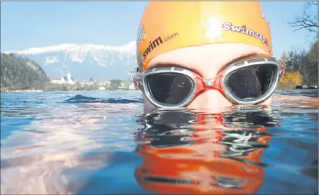  ??  ?? CHILLING OUT: Karen Weir, from Paisley, gets used to the water temperatur­e before the heat of competitio­n in the Bled Winter Cup, in Slovenia.