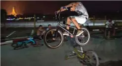  ??  ?? Young bikers performing stunts in front of people in a park at Yangon.