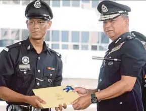  ?? FAZLIE SHAHRIZAL
PIC BY SHAHNAZ ?? Constable Mohd Norzulkhai­ree Md Akhir (left) receiving a certificat­e of appreciati­on from the Malaysian Anti-Corruption Commission from Penang police chief Datuk Chuah Ghee Lye at the state police headquarte­rs in George Town yesterday.