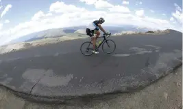  ?? David Zalubowski, AP file ?? A lone cyclist climbs the final turn to reach the summit along the Mount Evans Highway near Idaho Springs in 2016.