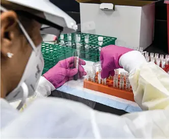  ?? Chandan Khanna/ AFP/Getty Images/TNS ?? ■ A lab technician sorts blood samples inside a lab for a COVID19 vaccine study at the Research Centers of America in Hollywood, Florida. So-called phase three vaccine clinical trials are gaining traction in Florida.